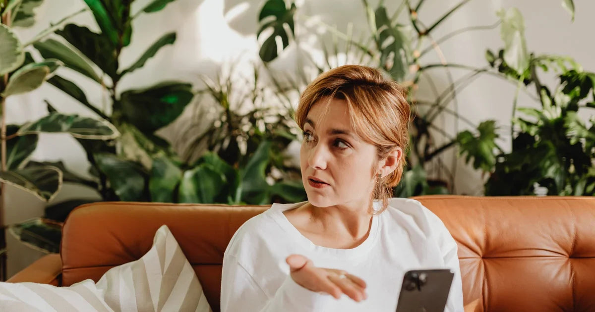 Nő telefonnal a kezében, épp nemet mond egy kérésre - határhúzás konkrét mondatokkal